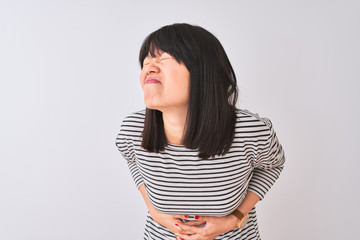 Young beautiful chinese woman wearing black striped t-shirt over isolated white background with hand on stomach because indigestion, painful illness feeling unwell. Ache concept.