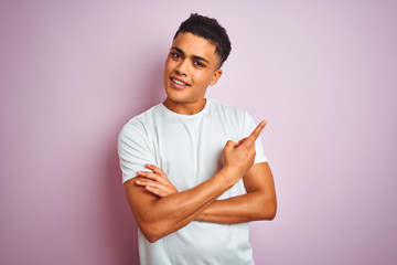 Young brazilian man wearing t-shirt standing over isolated pink background with a big smile on...