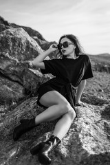 portrait of beautiful sexy brunette in sunglasses. fashionable young woman in short dress outdoors in Sunny weather enjoying summer. a man's t-shirt on a woman