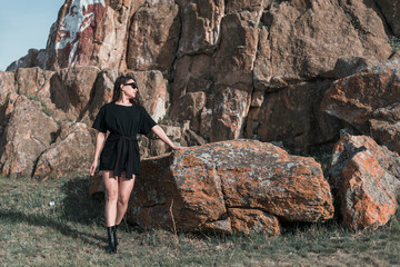 portrait of beautiful sexy brunette in sunglasses. fashionable young woman in short dress outdoors in Sunny weather enjoying summer. a man's t-shirt on a woman.