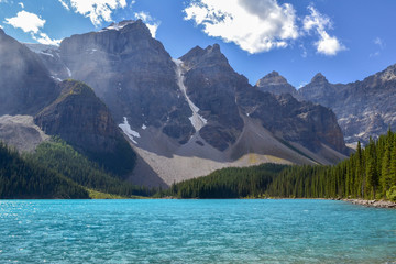Fototapeta na wymiar Iconic Canadian landscape, trip of a lifetime, Moraine Lake with it's glacier fed light blue turquoise waters and majestic peaks on a sunny day in the end of august, wilderness forest landscape.