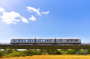 Rapid metro train is moving by elevated railway in panning effect photo style. Concept public electric transport with zero emissions. 