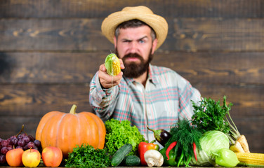 Grow organic crops. Community gardens and farms. Healthy lifestyle. Homegrown organic food. Man with beard wooden background. Become organic farmer. Farmer with organic homegrown vegetables