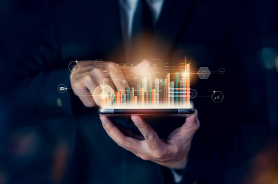Stock exchange market concept, hand trader holding tablet with graphs analysis candle line on bokeh colors light in night.