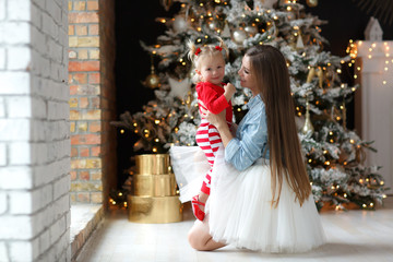 Family celebrates Christmas. Happy mother with daughter in magic night. Gifts, Christmas tree with yellow lights in the background. Merry Christmas.Tenderness, care and mutual understanding.Christmas 