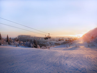 Ski slope and cable car at sunrise.