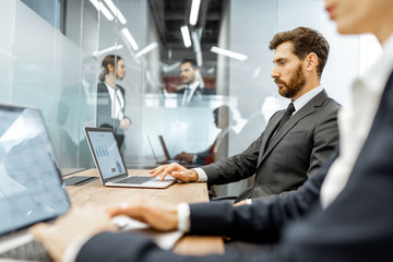White-collar employees working on the laptop at the working place in the finance department of a large corporation