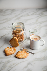 Italienische Blätterteig Fächer Kekse mit Einmachglas und Becher Kaffee auf Marmor Hintergrund