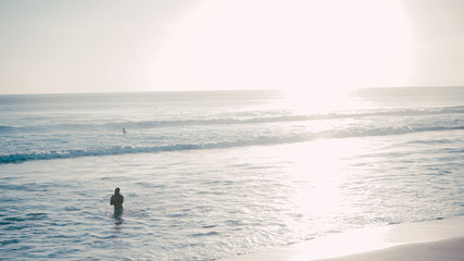 silhouette of surfer on beach at sunset