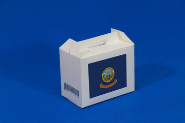 Idaho flag on white box with barcode and the color of state flag on blue background. The concept of export trading from Idaho.