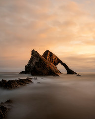 Bow Fiddle rock is located on the beautiful north coast of Scotland. Photo was taken at sunrise with very nice colors in the sky and with a long shutter speed