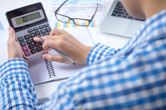 Financial Advisor Is Calculating And Analyzing The Data At The White Desk With All Graph Documents.