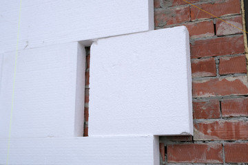 Close-up detail of brick house wall with rigid styrofoam insulation sheet. Modern technology of...