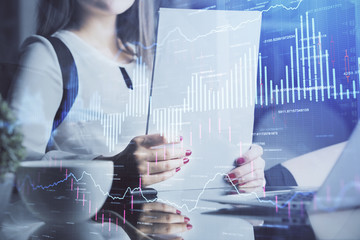Double exposure of hands making notes with forex chart huds. Stock market concept.
