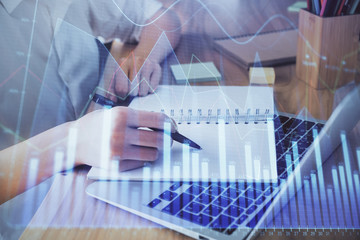 Financial charts displayed on woman's hand taking notes background. Concept of research. Double exposure