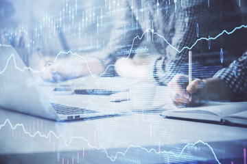 Multi exposure of forex chart with man working on computer on background. Concept of market...