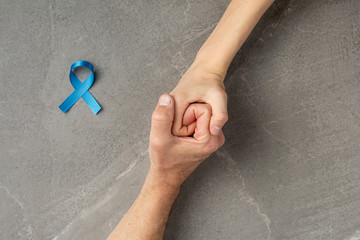 hands holding prostate cancer blue ribbon