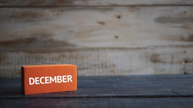 december 9th. Day 9 of month, calendar on a color cubes.  hand puts the day of the month on the name of the month on a wooden background winter, day of the year concept