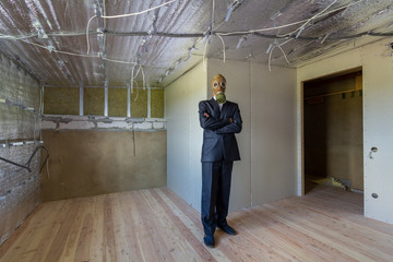 Strange man in businessman suit and gas protection mask inside a room under renovation works.