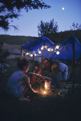 Obraz na płótnie Canvas Father with children playing under their backyard tent.