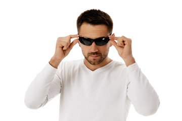 Young handsome bearded man wearing sunglasses on white background