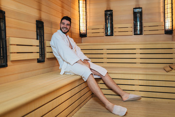 Handsome man relaxing in sauna and staying healthy