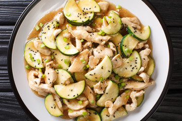 Tasty stewed chicken fillet with zucchini in spicy sauce close-up on a plate. Horizontal top view