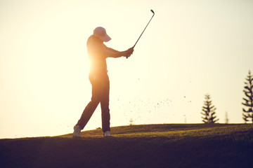 Golf swing on the course. Golfer performs a golf shot from the fairway. Sunny summer day. Concept: sport, relax, tourism, welfare. - obrazy, fototapety, plakaty