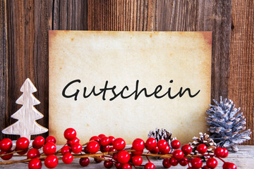 Fototapeta na wymiar Paper With German Text Gutschein Means Voucher. Christmas Decoration And Wooden Background