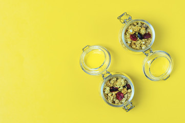 Muesli or Granola in a Glass Jars on Yellow Background Top View Healthy Breakfast Concept Diet Food