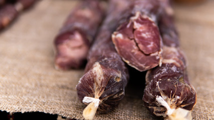 Closeup of a variety of cooked meats, salamis and sausages at a delicatessen