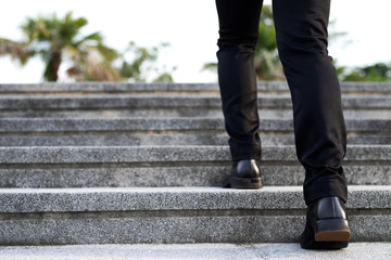modern businessman working  close-up legs walking up the stairs in modern city. in rush hour to work in office a hurry. During the first morning of work. stairway. soft focus.