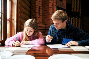 man and woman sign documents at a table in a cafe