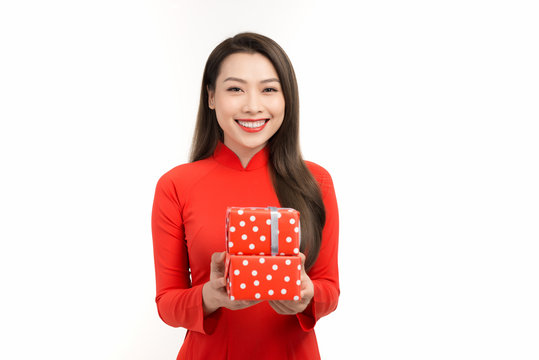 Beautiful woman in red ao dai dress holding gift box