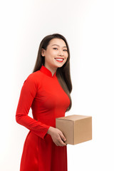 Portrait of an Asian girl in a traditional Vietnamese dress, ao dai, a good smile, holding gift box