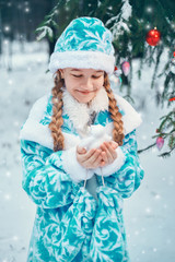 little girl holding a snowman in her arms. care concept