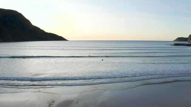 4K drone footage of people surfing during sunset at Hoddevik, Norway