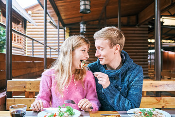 guy and girl have lunch together in a cafe. man and woman eat in a restaurant.