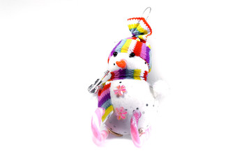 Fototapeta na wymiar Toy snowman on skis from a pink candy striped on a white background. Christmas souvenir.