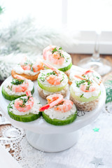 Assorted canapes with shrimps - with fresh cucumbers, cherry tomatoes, bread, crackers at the festive Christmas table, selective focus
