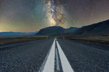 Milky way over mountains at the end of a long road. Scenery and night photography concept..........