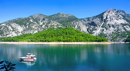 Fototapeta na wymiar Beautiful mountain lake landscape with motor yacht.