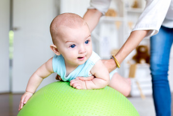 Exercise with a child on the ball. Professional baby massage at home.