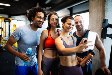 Group of sportive people in a gym taking selfie. Concepts about lifestyle and sport in fitness club
