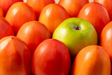 Juicy persimmons and green apple close-up.