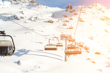 Ski lift ropeway on hilghland alpine mountain winter resort on bright sunny day. Ski chairlift...