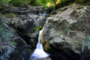 Naklejka na ściany i meble background photo of riverbank rocks, and water flow