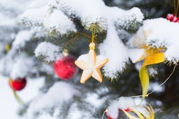 Christmas tree in snow background. New Year composition with fir tree, balls and lights and bokeh.
