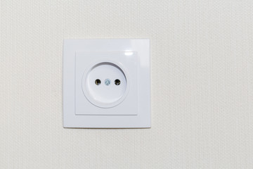 White french/european electrical outlet/plug on a wall.