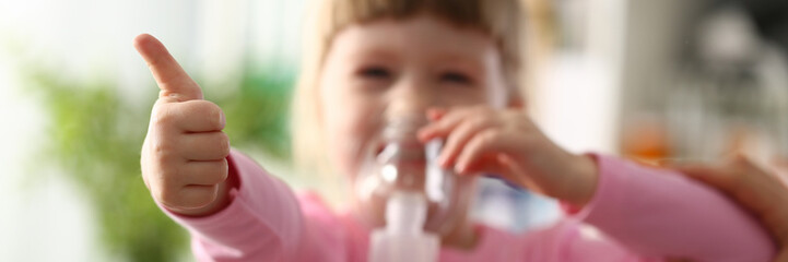 Happy child makes inhalation at home for